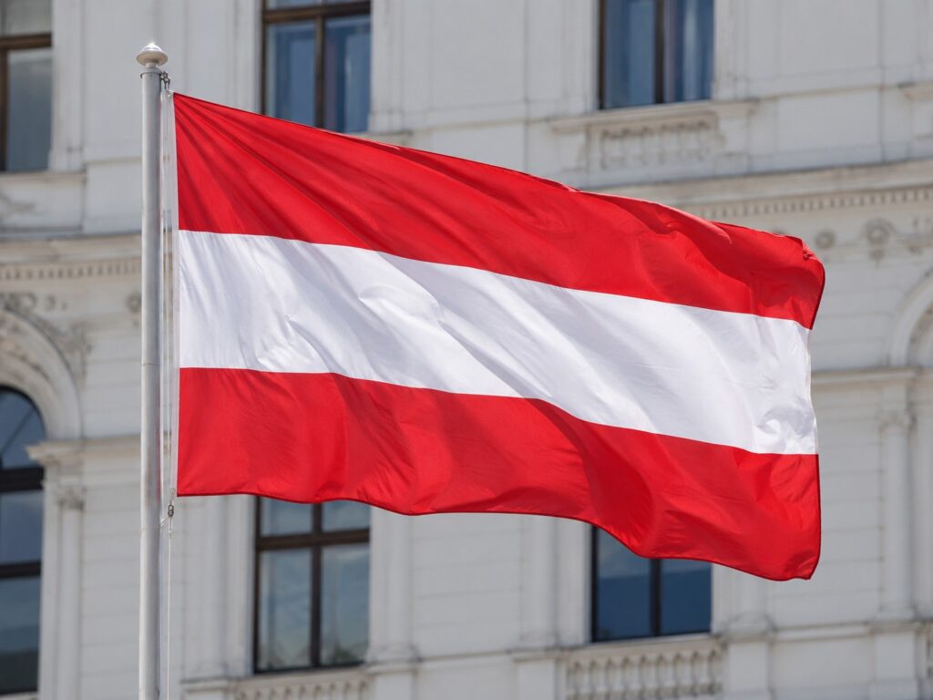 Flaga Austrii powiewająca na wietrze, transport ciężarowy do Austrii i z Austrii do Polski
